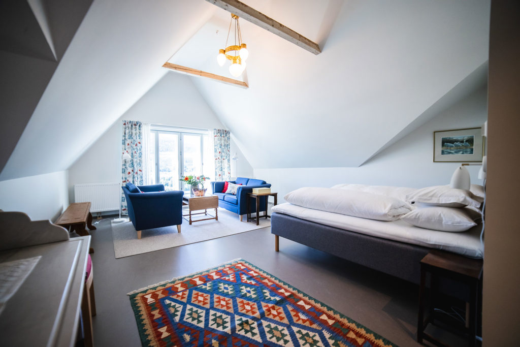 Bilde av suite på Steien Hotel med stor seng, sofagruppa og store vinduer